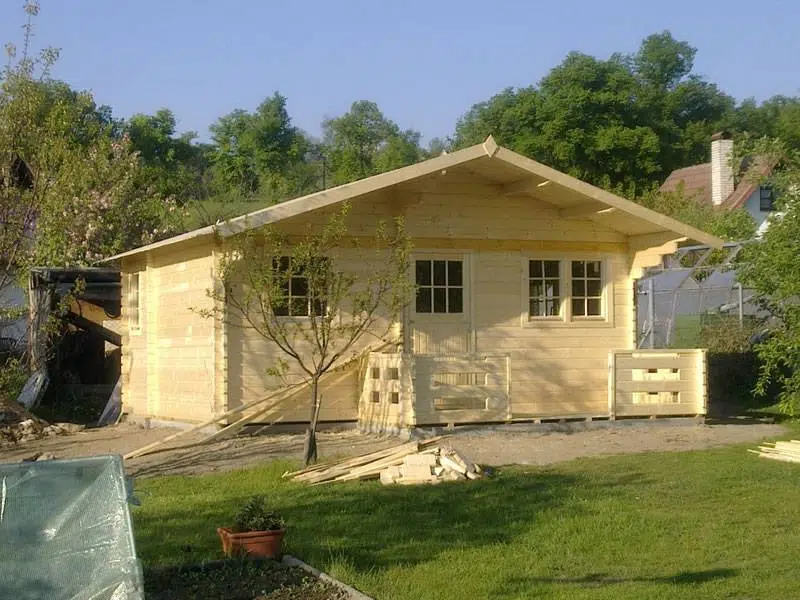 zahradní domek s přístreškem, terasou a dřevěným zábradlím v zahradě