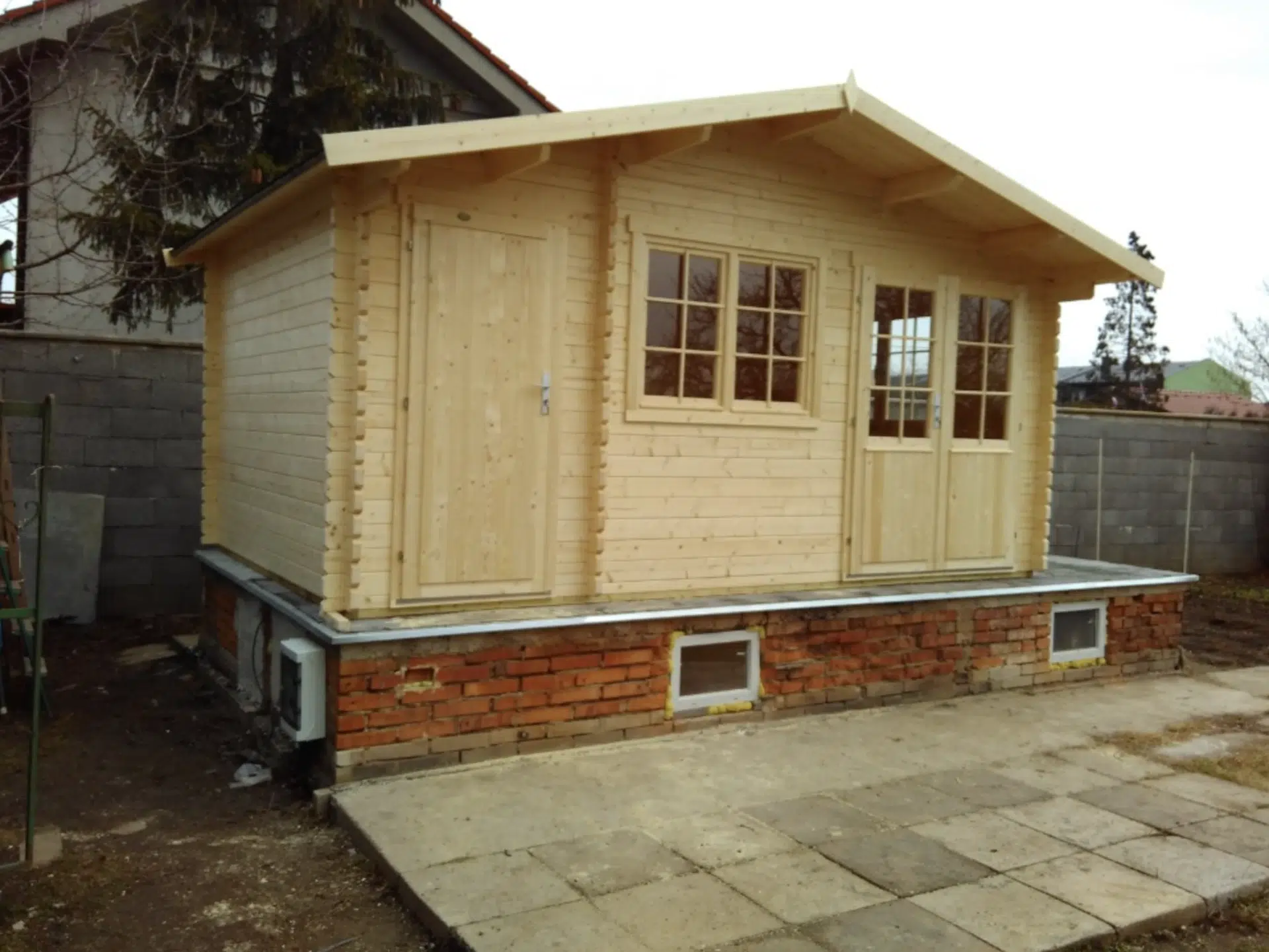 Fotografie dřevěného zahradního domku Borkum během realizace na betonové ploše.